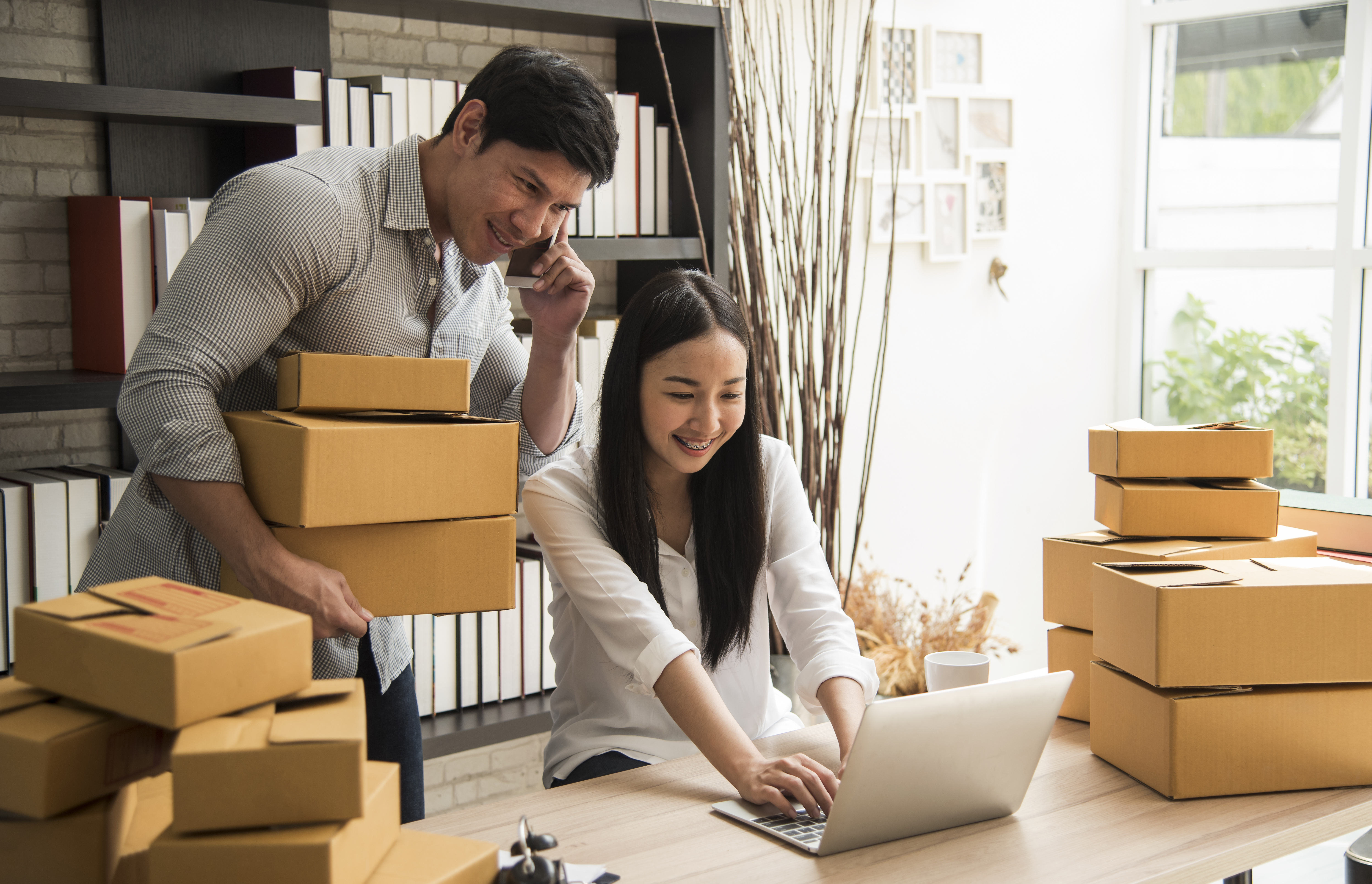 Owners of a small business at a warehouse accepting orders 